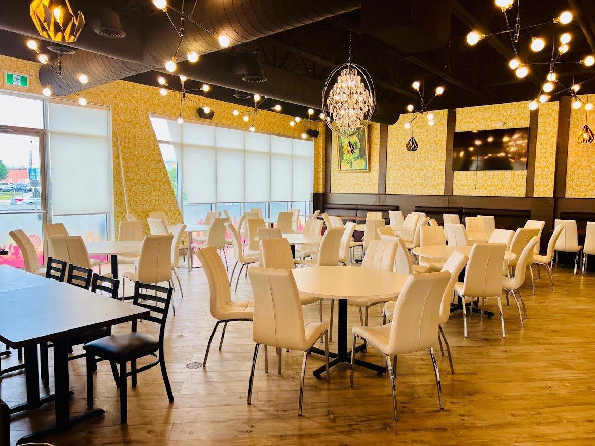 The Saffron dining hall set for service, with chandeliers and gold accents